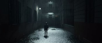 Movie still from “Suburra” (2015), directed by Stefano Sollima – A person standing in the middle of an alley in the rain; Extreme Wide shot, Low angle