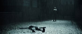 Movie still from “Suburra” (2015), directed by Stefano Sollima – A person laying on the ground in the middle of a rain storm; Wide shot, High angle