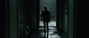 Movie still from “Suburra” (2015), directed by Stefano Sollima – A person walking in the rain through a doorway; Wide shot, Low angle