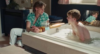 Movie still from “Summer of 85” (2020), directed by François Ozon – Two people sitting in a bath tub talking to each other; Medium shot, Over the shoulder angle