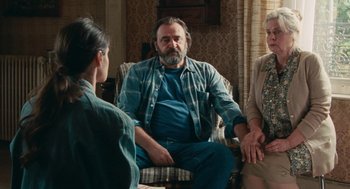 Movie still from “Summer of 85” (2020), directed by François Ozon – A group of people sitting in a living room talking; Medium shot, Over the shoulder angle