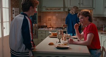 Movie still from “Summer of 85” (2020), directed by François Ozon – A group of people in a kitchen eating food; Medium shot, Over the shoulder angle