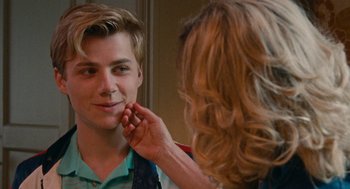 Movie still from “Summer of 85” (2020), directed by François Ozon – A woman is putting lipstick on a young man's face; Close Up shot, Over the shoulder angle