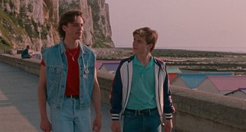 Movie still from “Summer of 85” (2020), directed by François Ozon – Two young men are walking along a pier; Medium shot, Low angle
