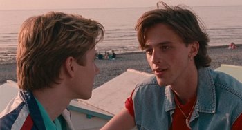 Movie still from “Summer of 85” (2020), directed by François Ozon – Two young men talking on the beach near the water; Close Up shot, Over the shoulder angle