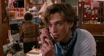 Movie still from “Summer of 85” (2020), directed by François Ozon – A man sitting at a table talking on a phone; Close Up shot, Over the shoulder angle