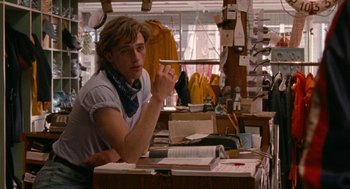 Movie still from “Summer of 85” (2020), directed by François Ozon – A man sitting at a desk in a room; Medium shot, Over the shoulder angle