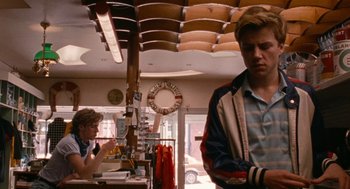 Movie still from “Summer of 85” (2020), directed by François Ozon – A man standing in front of another man in a store; Medium shot, Over the shoulder angle