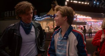 Movie still from “Summer of 85” (2020), directed by François Ozon – Two young men talking to each other at an amusement park; Medium shot, Over the shoulder angle