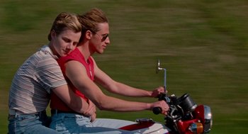 Movie still from “Summer of 85” (2020), directed by François Ozon – A man and a woman sitting on a motorcycle; Medium shot, High angle