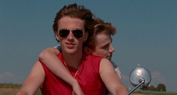 Movie still from “Summer of 85” (2020), directed by François Ozon – Two young men are riding a motorcycle together; Medium shot, Over the shoulder angle