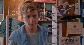Movie still from “Summer of 85” (2020), directed by François Ozon – A young man standing in front of a rack of sunglasses; Close Up shot, Over the shoulder angle