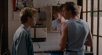 Movie still from “Summer of 85” (2020), directed by François Ozon – A group of young men standing in front of a bathroom mirror; Medium shot, Over the shoulder angle
