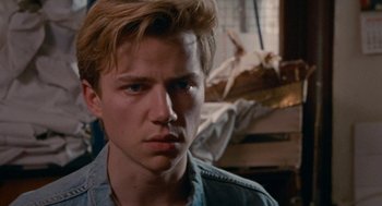 Movie still from “Summer of 85” (2020), directed by François Ozon – A man with blonde hair and blue eyes stares into the camera; Close Up shot, Over the shoulder angle