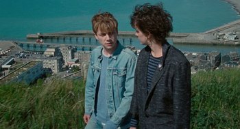 Movie still from “Summer of 85” (2020), directed by François Ozon – Two young people standing next to each other on top of a hill; Medium shot, High angle