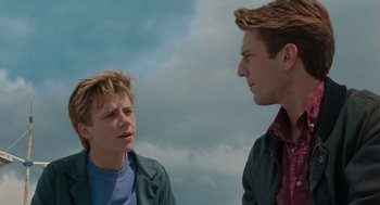 Movie still from “Summer of 85” (2020), directed by François Ozon – Two young men talking to each other in front of a cloudy sky; Close Up shot, Low angle