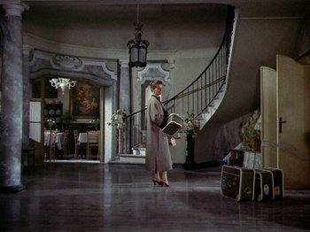 Movie still from “Summertime” (1955), directed by David Lean – A woman is walking down the stairs in a hotel lobby; Wide shot, High angle