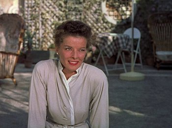 Movie still from “Summertime” (1955), directed by David Lean – A woman is smiling for the camera outside; Medium shot, Low angle