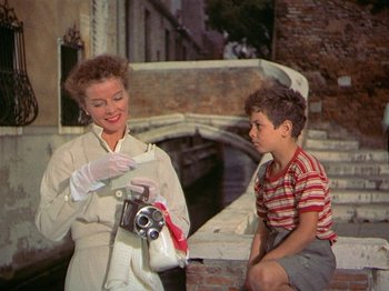 Movie still from “Summertime” (1955), directed by David Lean – A woman and a young boy holding a camera; Medium shot, Low angle