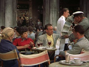Movie still from “Summertime” (1955), directed by David Lean – A group of people sitting at a table with wine glasses; Medium shot, High angle