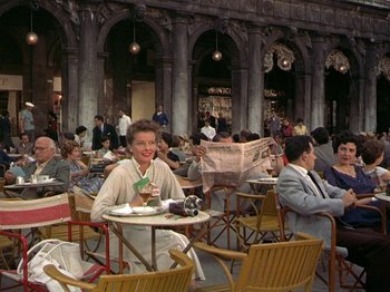 Movie still from “Summertime” (1955), directed by David Lean – A group of people sitting at tables in an outdoor cafe; Wide shot, High angle
