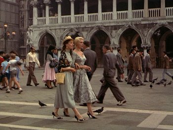 Movie still from “Summertime” (1955), directed by David Lean – A couple of women walking across a street; Wide shot, Low angle