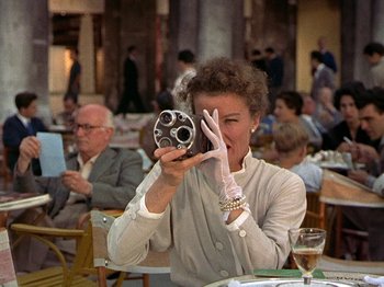 Movie still from “Summertime” (1955), directed by David Lean – An older woman holding a camera in her hands; Medium shot, Low angle