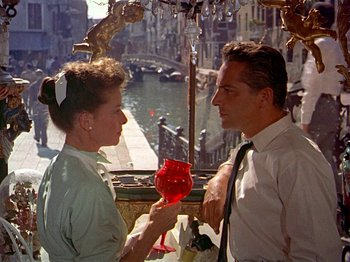 Movie still from “Summertime” (1955), directed by David Lean – A man and a woman are holding a glass of wine; Medium shot, High angle