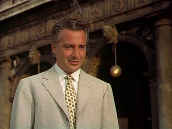 Movie still from “Summertime” (1955), directed by David Lean – A man in a suit and tie standing in front of a building; Close Up shot, Low angle