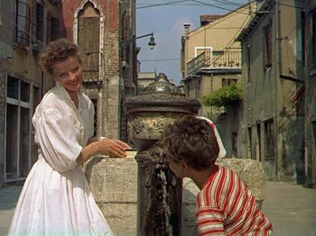 Movie still from “Summertime” (1955), directed by David Lean – A woman and a boy drinking water from a water fountain; Medium shot, Low angle