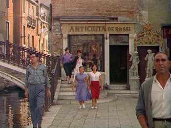 Movie still from “Summertime” (1955), directed by David Lean – A group of people walking down a street; Wide shot, High angle