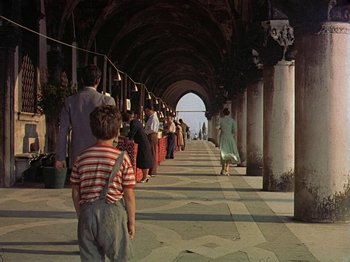 Movie still from “Summertime” (1955), directed by David Lean – A group of people walking down a sidewalk; Wide shot, Low angle