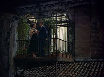 Movie still from “Summertime” (1955), directed by David Lean – A man and a woman standing next to a balcony; Wide shot, Low angle