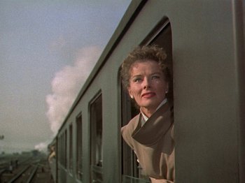 Movie still from “Summertime” (1955), directed by David Lean – A woman looking out of a window on a train; Medium shot, Low angle