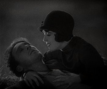 Movie still from “Sunrise” (1927), directed by F.W. Murnau – A man and a woman embracing each other in a black and white photo; Close Up shot, High angle