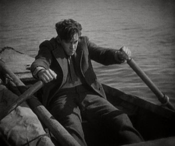 Movie still from “Sunrise” (1927), directed by F.W. Murnau – A man rowing a boat on a lake; Medium shot, High angle