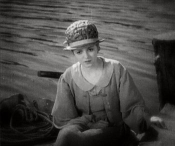 Movie still from “Sunrise” (1927), directed by F.W. Murnau – A woman sitting on the back of a boat in the middle of the water; Medium shot, High angle