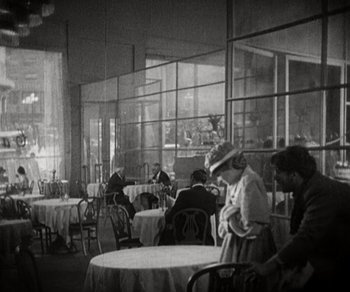 Movie still from “Sunrise” (1927), directed by F.W. Murnau – A black and white photo of people sitting at tables in a restaurant; Wide shot, High angle