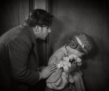 Movie still from “Sunrise” (1927), directed by F.W. Murnau – An old photo of a man and a young girl; Medium shot, High angle