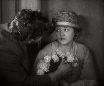 Movie still from “Sunrise” (1927), directed by F.W. Murnau – An old photo of a woman and a child holding flowers; Close Up shot, High angle
