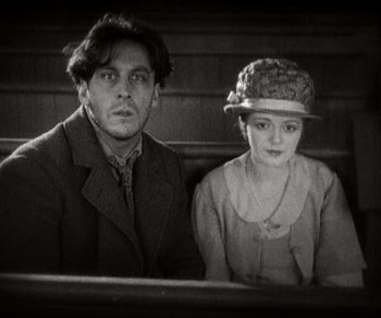 Movie still from “Sunrise” (1927), directed by F.W. Murnau – A man and a woman sitting on a bench; Medium shot, Low angle