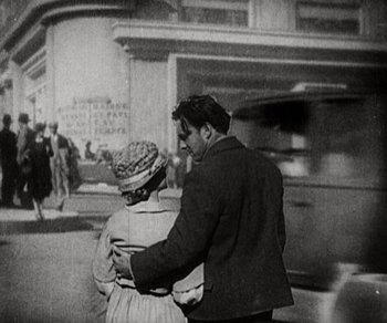 Movie still from “Sunrise” (1927), directed by F.W. Murnau – A man and a woman holding hands on a street; Medium shot, Low angle