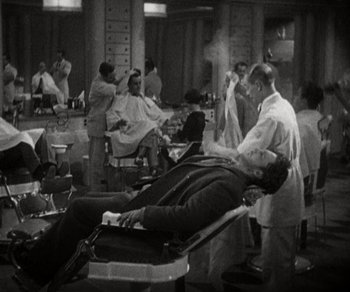 Movie still from “Sunrise” (1927), directed by F.W. Murnau – An old photo of a man getting his teeth waxed; Medium shot, High angle