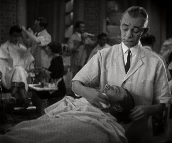 Movie still from “Sunrise” (1927), directed by F.W. Murnau – An old photo of a man shaving another man's head; Medium shot, Over the shoulder angle