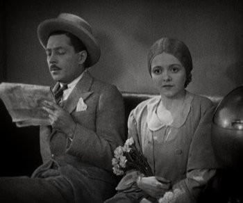 Movie still from “Sunrise” (1927), directed by F.W. Murnau – A man and a woman sitting next to each other on a couch; Medium shot, High angle