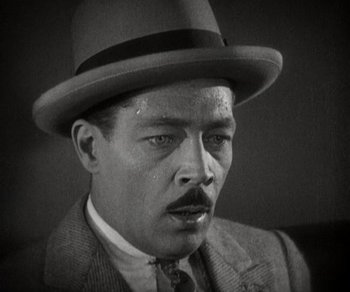 Movie still from “Sunrise” (1927), directed by F.W. Murnau – A man in a suit and a hat is posing for a picture; Close Up shot, High angle