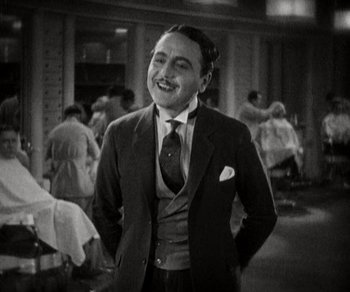 Movie still from “Sunrise” (1927), directed by F.W. Murnau – A black and white photo of a man in a suit; Medium shot, High angle