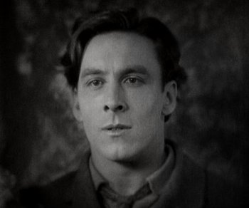 Movie still from “Sunrise” (1927), directed by F.W. Murnau – Black and white photograph of a man in a suit; Close Up shot, Low angle