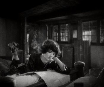 Movie still from “Sunrise” (1927), directed by F.W. Murnau – A woman sitting at a table looking at a map; Medium shot, High angle