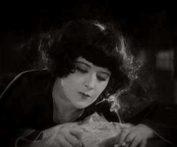 Movie still from “Sunrise” (1927), directed by F.W. Murnau – An old photograph of a woman smoking a cigarette; Close Up shot, High angle